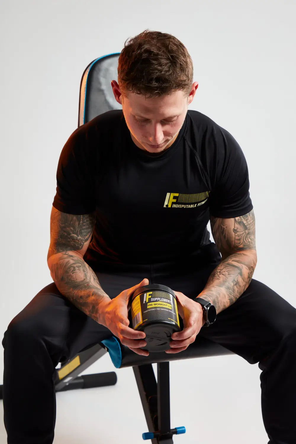 Man holding a black and yellow supplement container with Beta Alanine for peak performance