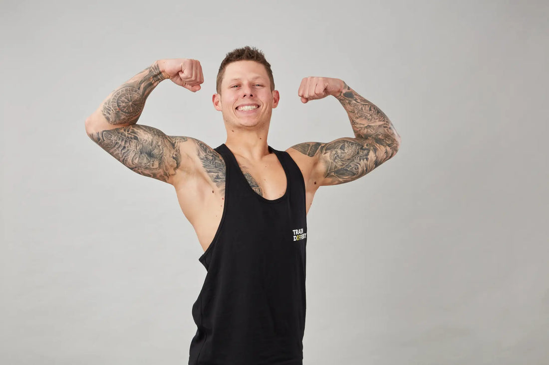 Muscular man flexing arms to inspire building a consistent workout routine and stay motivated