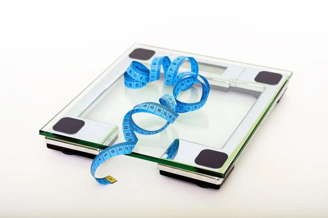 Glass-topped digital scale with blue measuring tape, a convenient tool for accurate home scales.