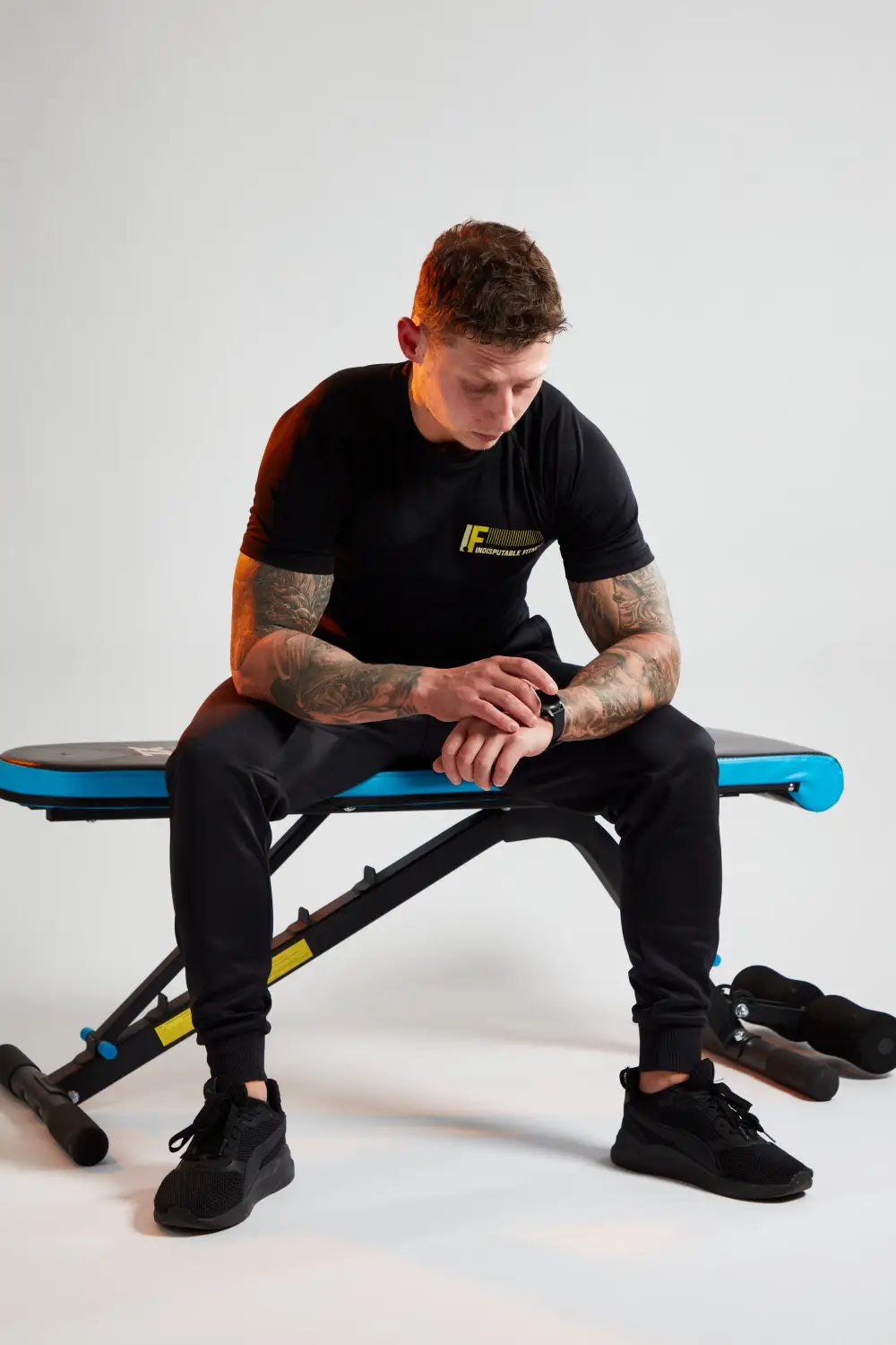 Man sitting on a weight bench relaxing to manage stress and pressure in your career