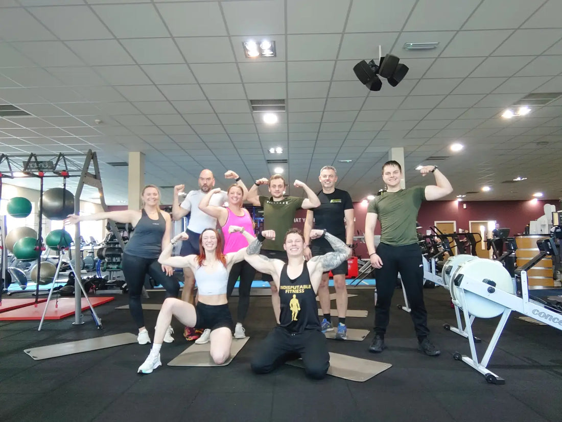Group fitness class with gym-goers flexing muscles in a beginners survival guide setting