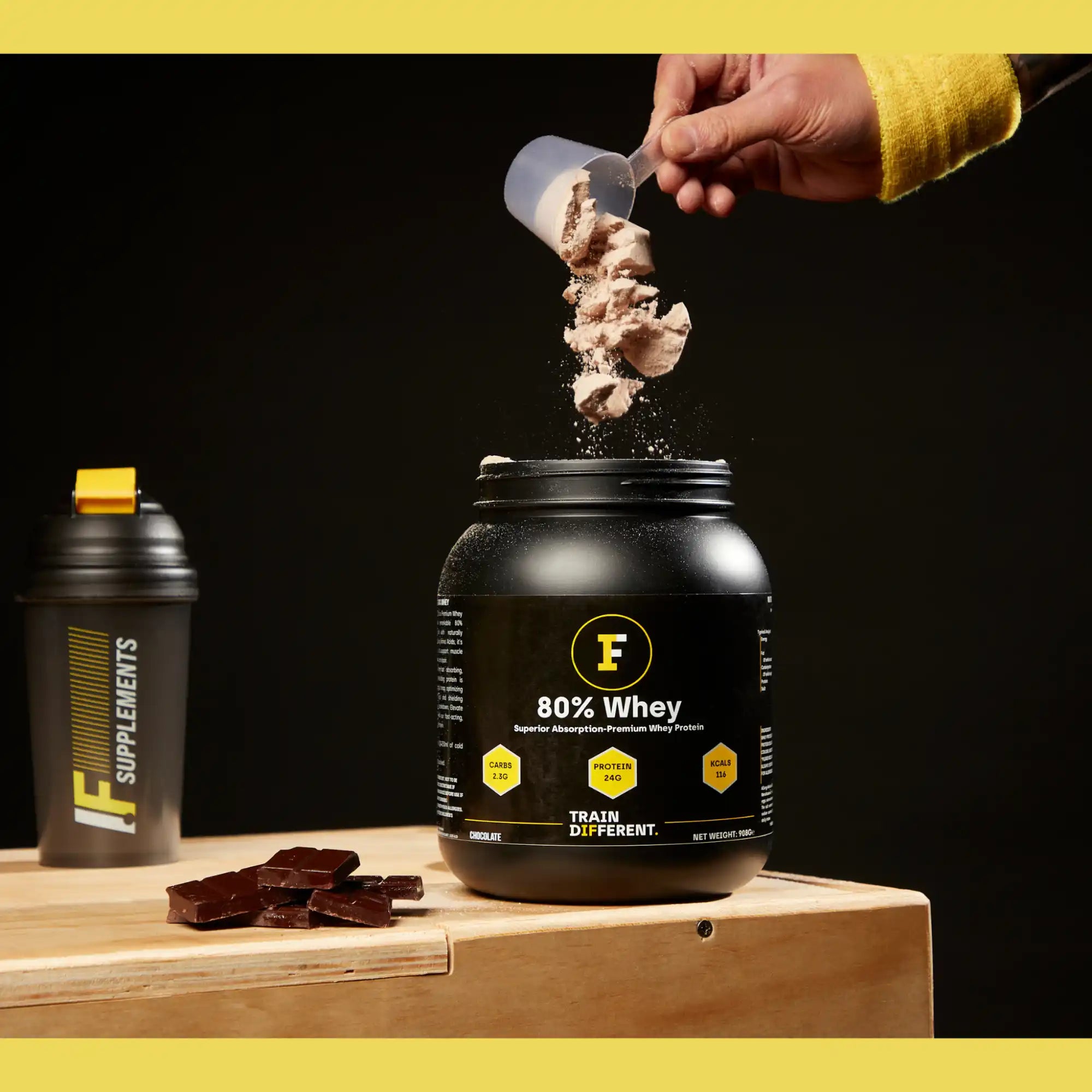 Black protein powder container with a yellow ’F’ logo and ’80% Whey’ text.